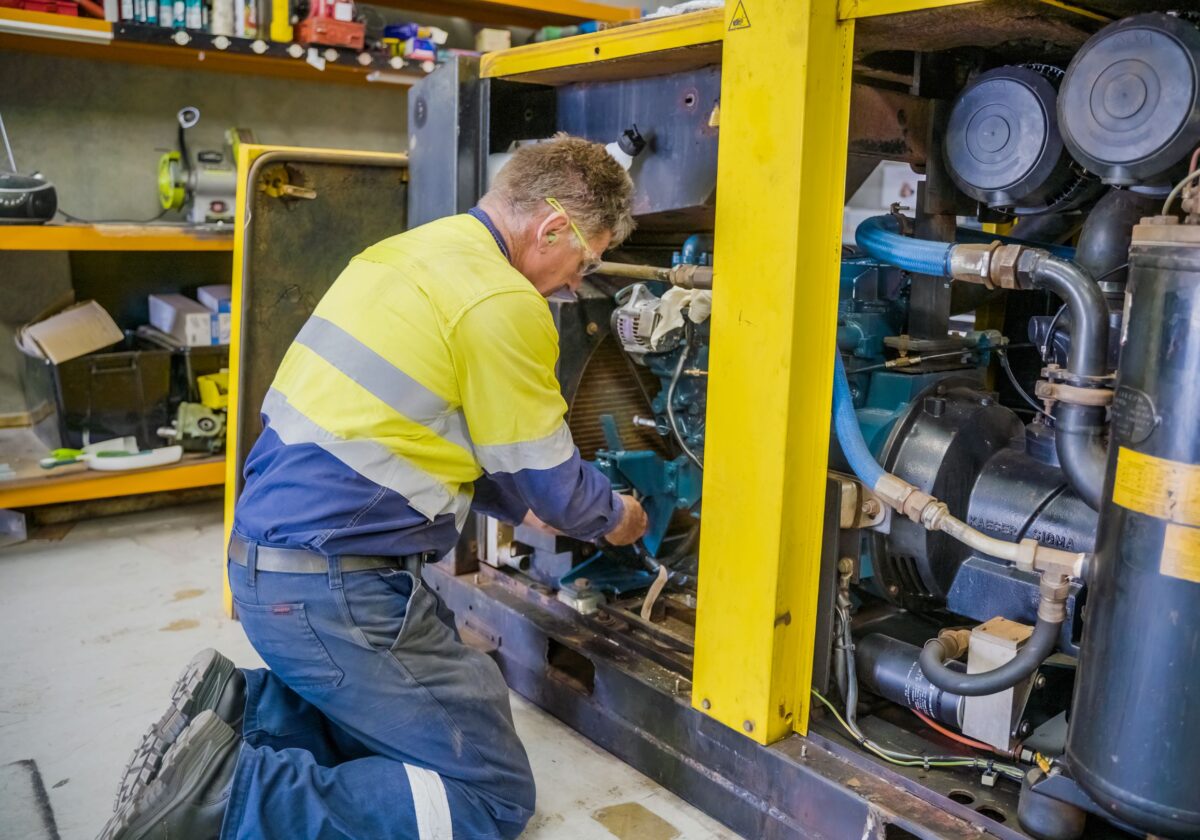 A compressed air service technician services a compressor in Perth, ready for summer